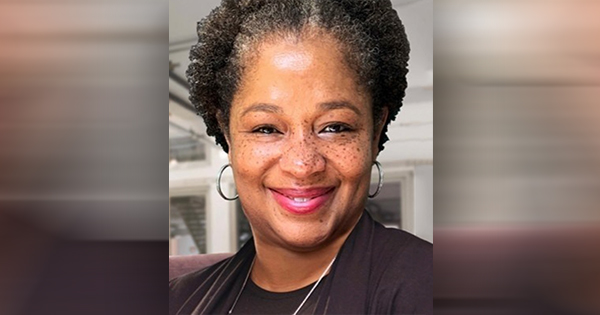 Robin Boyd, a professional and confident African American woman, standing in front of her team at Essential Accounting Consultants, all smiling and ready to assist small businesses with financial management.